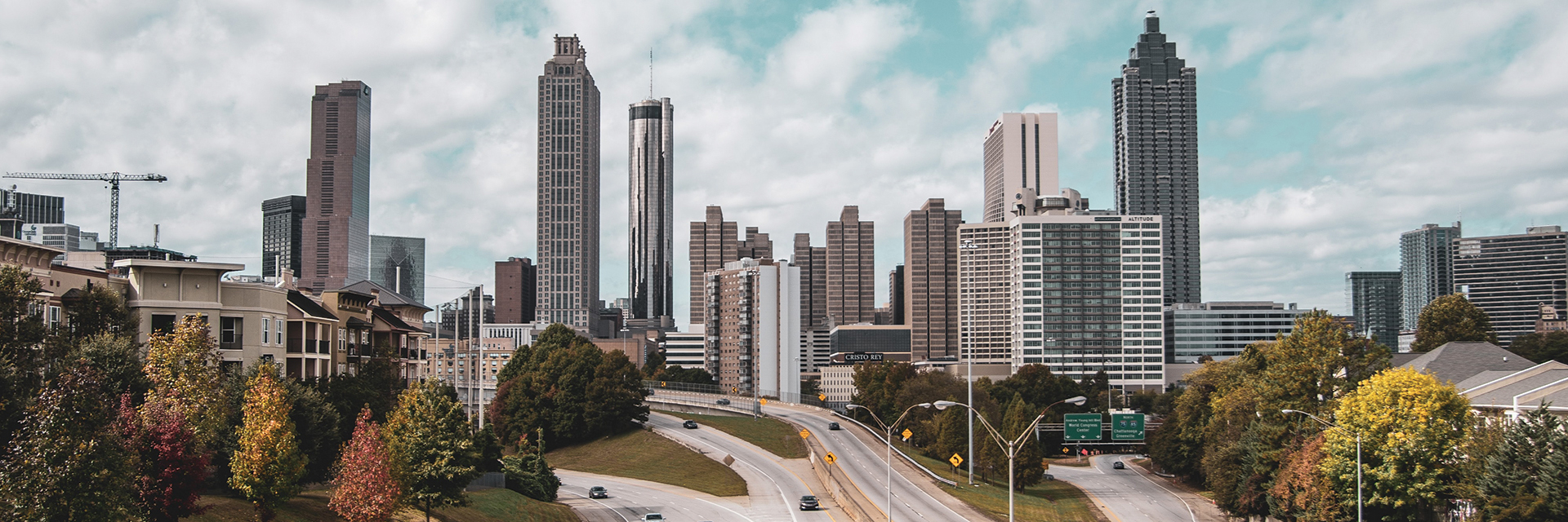 The Atlanta skyline with a highway leading towards the buildings.
